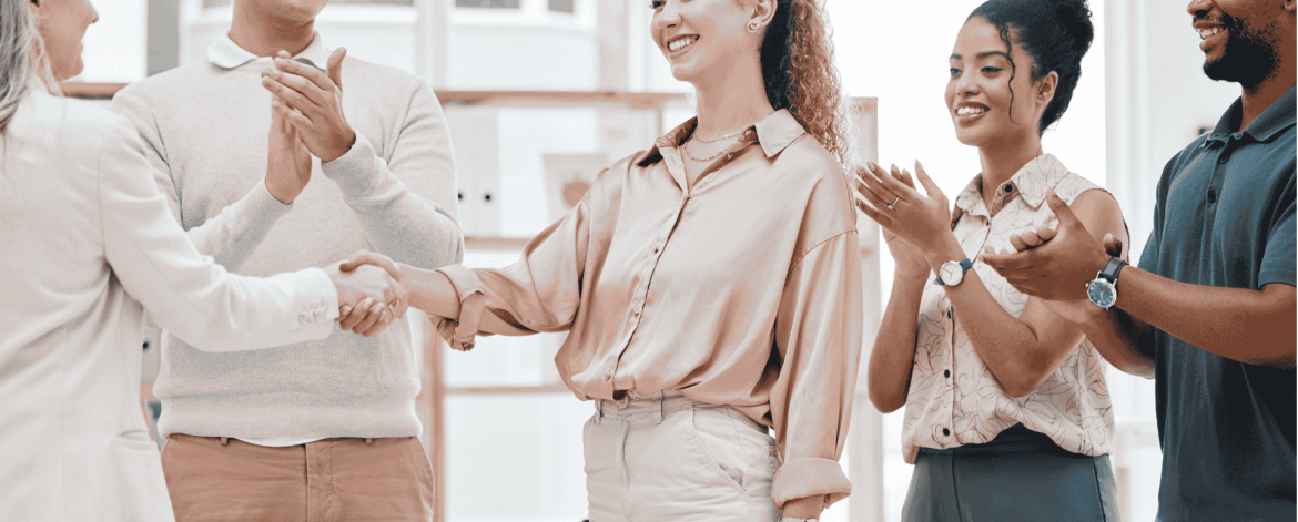 Team welcoming a new employee with handshakes and applause – smooth IT onboarding ensuring proper access, permissions, and device setup.