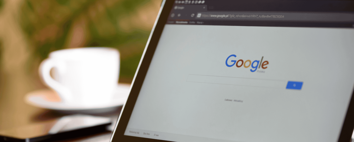 User accessing Google search on a smartphone while working on a laptop during a Google Cloud and Google Workspace migration.