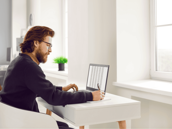 Professional reviewing data on a laptop during a Microsoft Cloud migration focused on secure file access and collaboration.