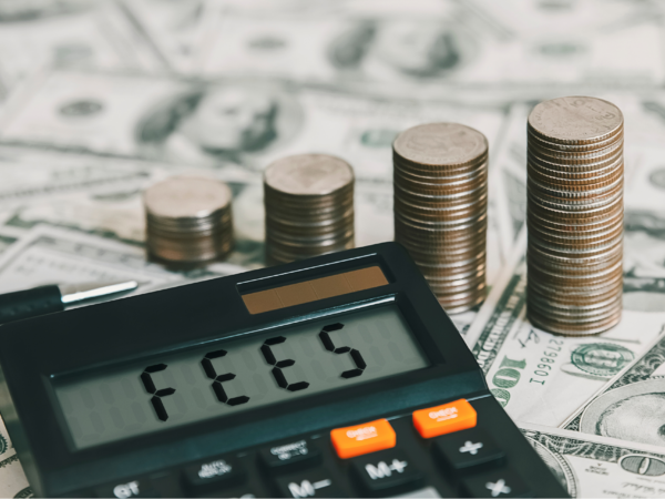 Calculator displaying fees with stacked coins and dollar bills representing unexpected IT service costs and hidden MSP fees