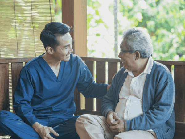 Caregiver helping senior patient use a tablet for secure access to healthcare information and digital systems in home-based care