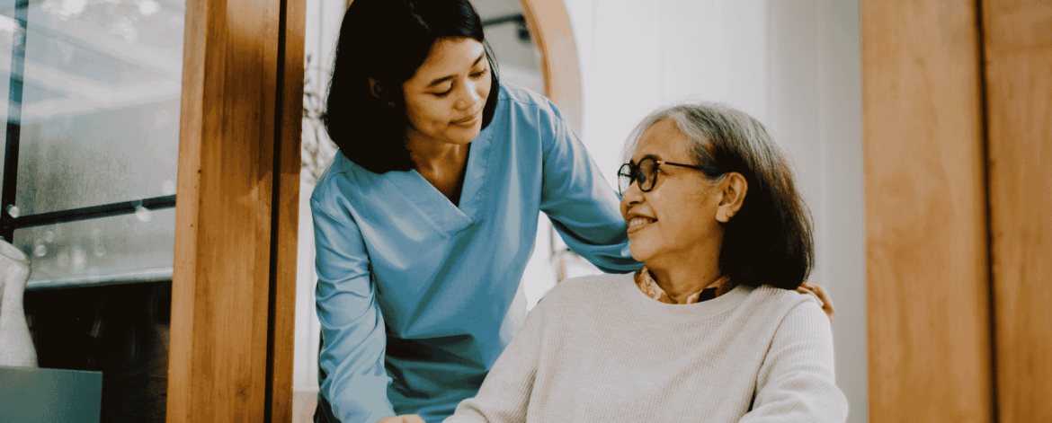Caregiver assisting elderly woman in wheelchair at home highlighting the importance of secure systems to protect patient data in home-based care environments