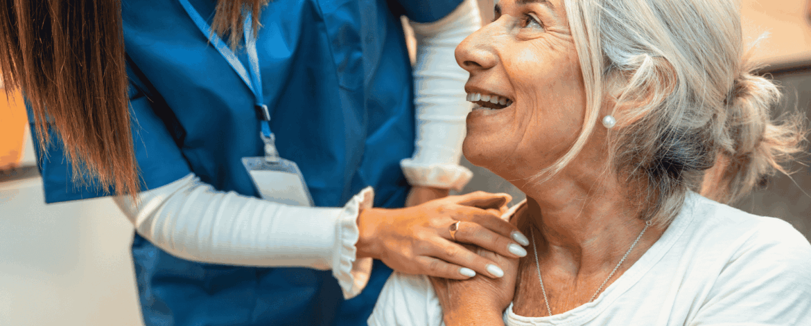 Caregiver supporting senior woman during home visit emphasizing the role of cybersecurity and data protection in delivering safe and reliable home-based care services