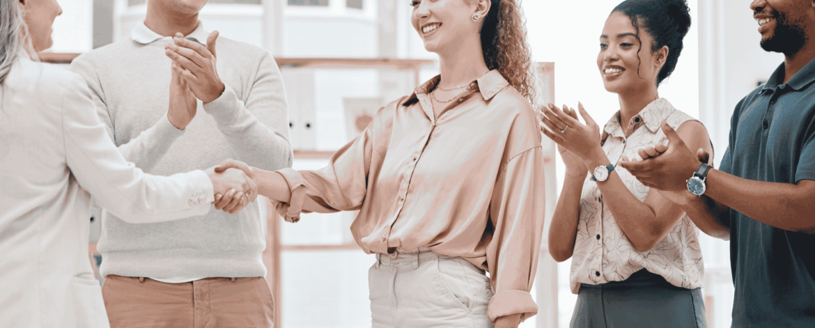 Business professionals shaking hands during a team meeting representing successful employee onboarding and workplace collaboration for home care agencies