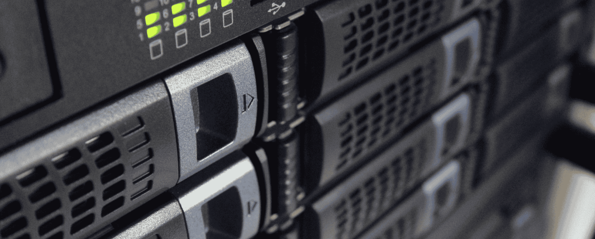 Close-up view of server racks with multiple hard drive bays and indicator lights, showing an active data center or IT infrastructure setup.