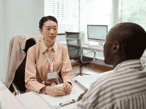 Manager and employee in an off-boarding meeting reviewing final steps – secure removal of system access and retrieval of company devices.