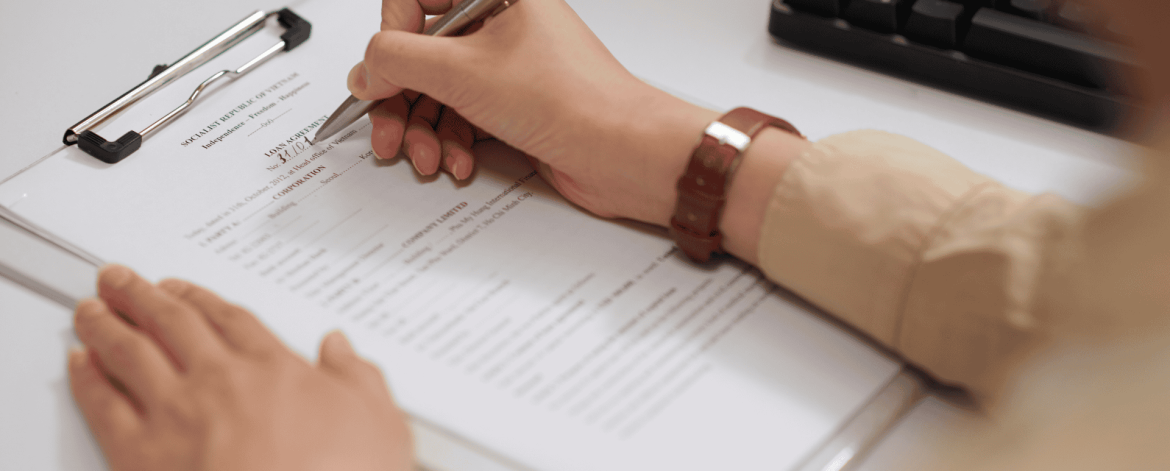 Close-up of a person completing paperwork during the employee off-boarding process – documenting account deactivation and data security procedures.