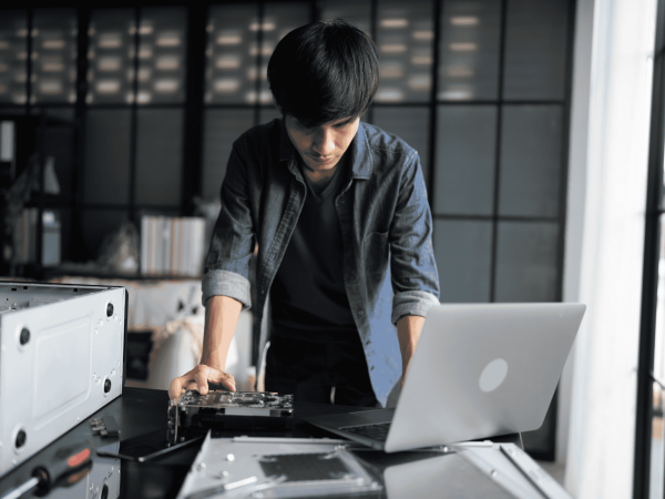 Woman making an online technology purchase using a tablet and credit card as part of a structured IT hardware acquisition process.