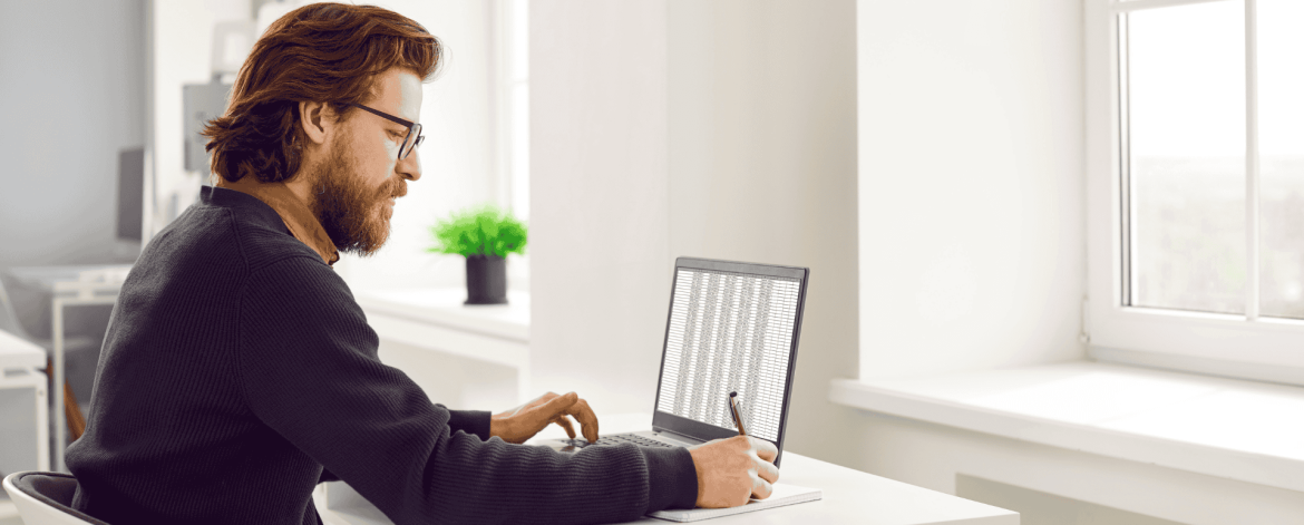 Professional reviewing data on a laptop during a Microsoft Cloud migration focused on secure file access and collaboration.