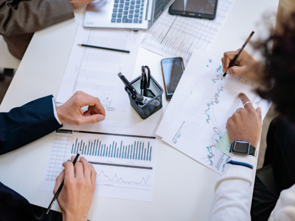 Team analyzing charts and system performance metrics to evaluate technical debt, infrastructure risk, and cybersecurity vulnerabilities