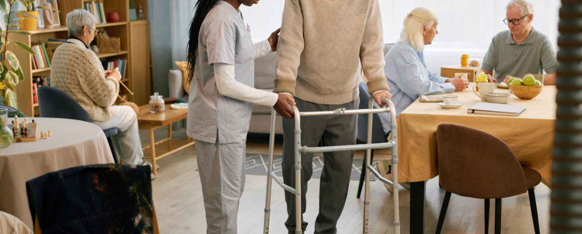 Home healthcare provider reviewing patient information on laptop with senior client in living room setting using secure managed IT services