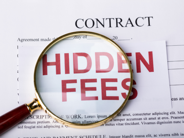 Magnifying glass over contract highlighting hidden fees in managed IT service agreements