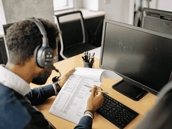 IT manager guiding support staff in a control room environment, showing the advantages of professional managed IT services over non-IT employee support.