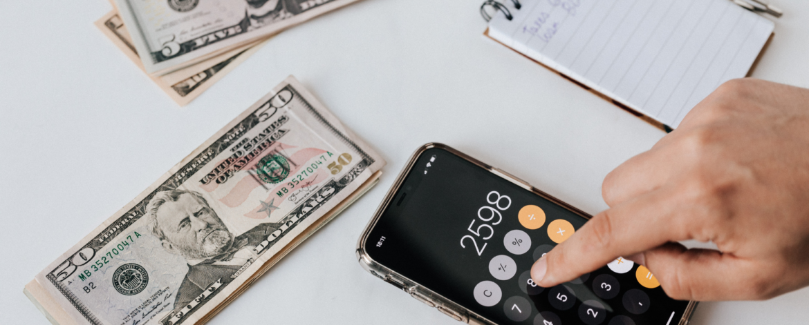 Business owner calculating unexpected IT support costs on smartphone illustrating hidden managed service provider charges