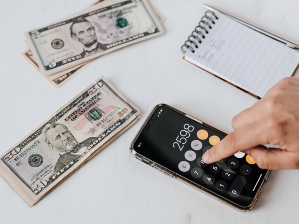 Business owner calculating unexpected IT support costs on smartphone illustrating hidden managed service provider charges