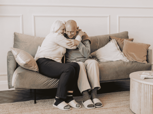 Senior couple embracing at home representing trust and importance of safeguarding sensitive patient information through secure cloud backup solutions.