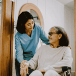 Caregiver assisting elderly woman in wheelchair at home highlighting the importance of secure systems to protect patient data in home-based care environments