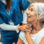 Caregiver supporting senior woman during home visit emphasizing the role of cybersecurity and data protection in delivering safe and reliable home-based care services