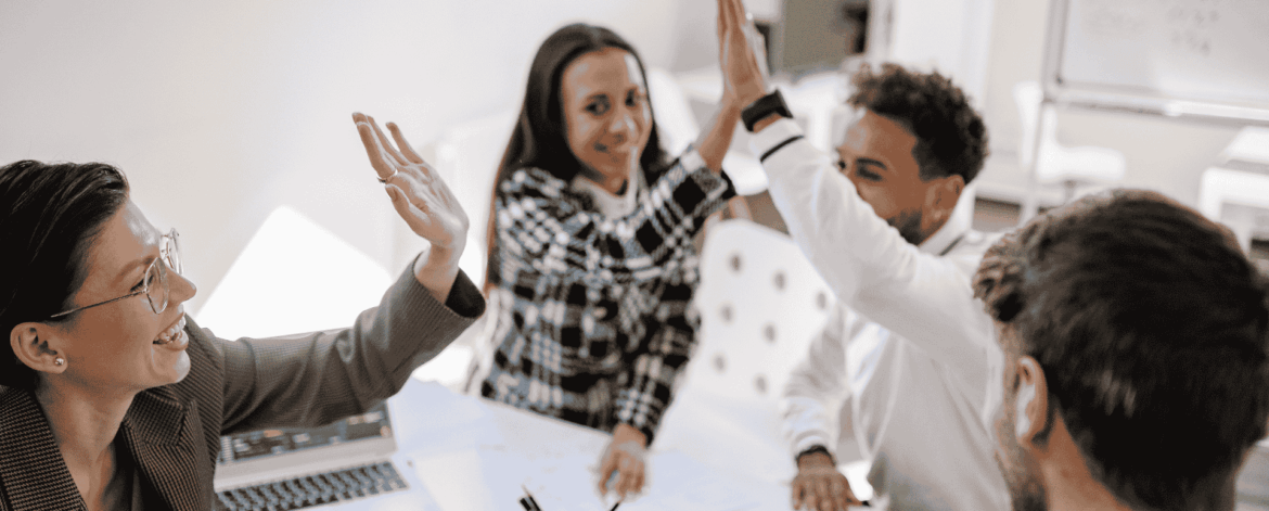 Employee Onboarding for Home Care Agencies 3 Team members celebrating together during a collaborative office meeting symbolizing engagement, communication, and employee onboarding success in home care organizations