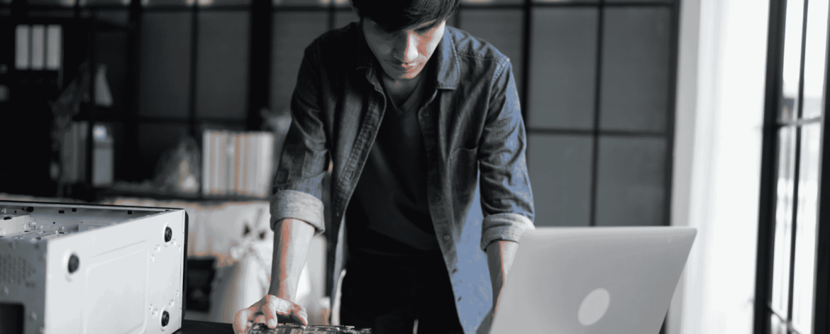 Hardware Lifecycle Management 3 IT technician servicing mobile devices and computer hardware at a workstation, supporting hardware lifecycle management, repairs, and device replacement planning for organizations
