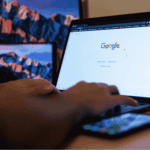 Home care coordinator using Google Workspace on a laptop and smartphone to manage client records and team communication, with multiple devices displaying Google on screen.