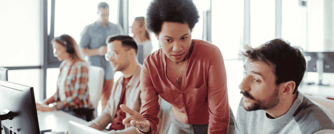 IT support team assisting employees with cybersecurity best practices and secure computer usage in an office environment