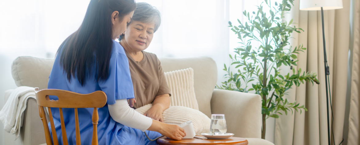 In home caregiver checking senior patient vital signs during home based care visit supported by compliant healthcare technology