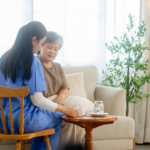 In home caregiver checking senior patient vital signs during home based care visit supported by compliant healthcare technology