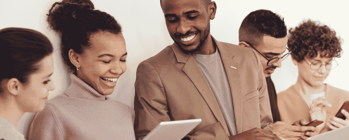 How Home Based Care Companies Can Manage and Secure their Teams Mobile Devices 1 Diverse team of home care professionals using smartphones, tablets, and laptops together, representing mobile device management and secure team communication for home-based care agencies.