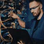 Open laptop undergoing hardware inspection and setup, representing device procurement, configuration, and deployment processes for home-based care agencies