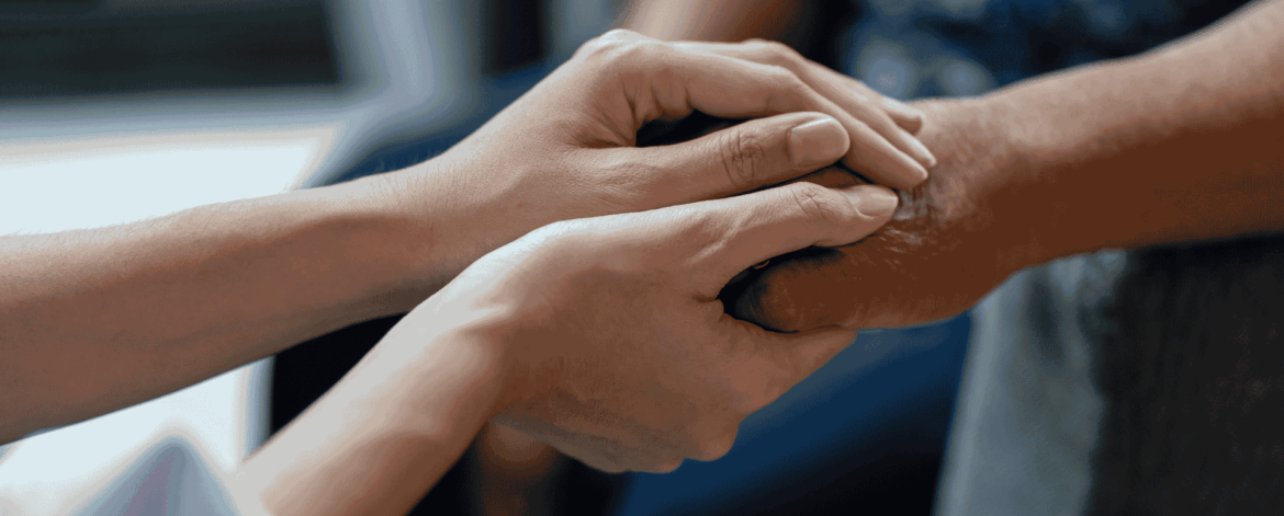 Network Stability 2 Close-up of caregiver holding an elderly patient’s hands representing dependable communication and stable technology systems in home-based care services.