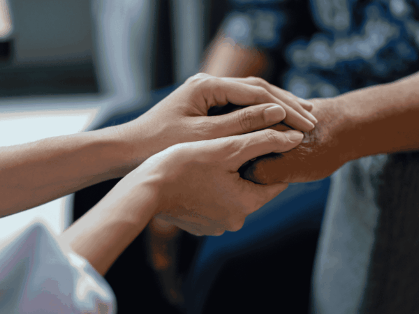 Network Stability 2 Close-up of caregiver holding an elderly patient’s hands representing dependable communication and stable technology systems in home-based care services.