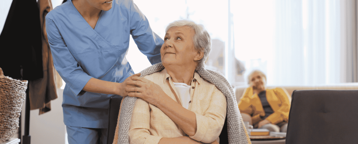 Caregiver holding an elderly client's hand during a home visit, the setting behind the HIPAA Security Rule update home health agencies are tracking in 2026.