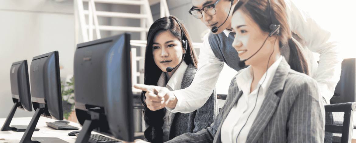 Support team in headsets working through a screen together at a shared desk, the vendor coordination a HIPAA shared responsibility matrix puts in writing.
