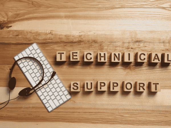 Wooden letter blocks spelling technical support beside a keyboard and headset, the help desk that fields questions like how long must a hospice keep patient records.
